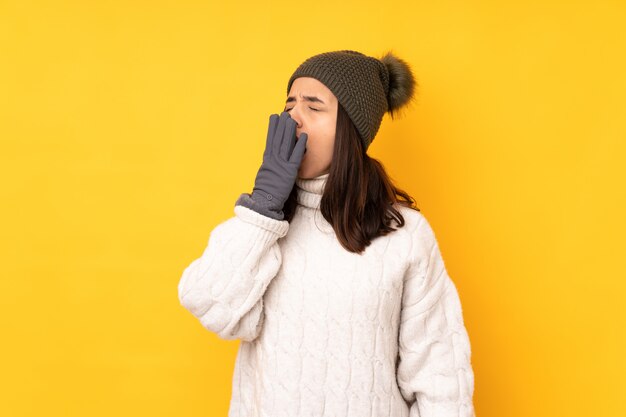 Moça com chapéu do inverno sobre a parede