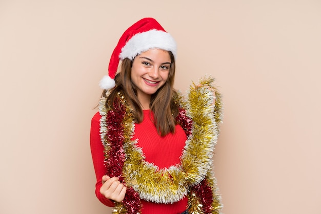 Moça com chapéu do Natal sobre a parede isolada