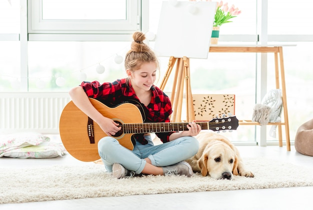 Moça com guitarra perto de cachorro