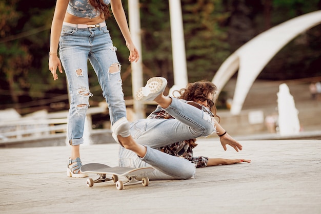 Foto moça com skate na parede cinza grande.