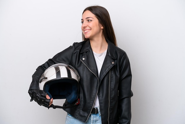 Moça com um capacete de moto isolado no fundo branco, olhando de lado