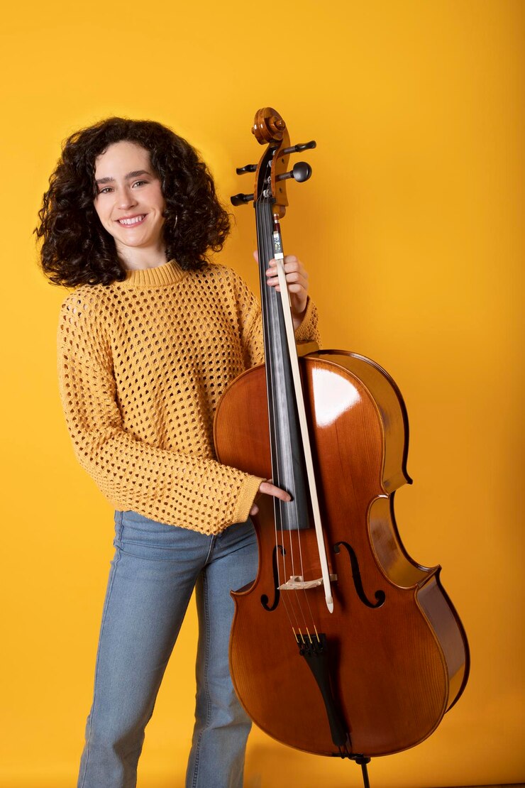 Foto moça com violoncelo e roupas casuais em tons ocres