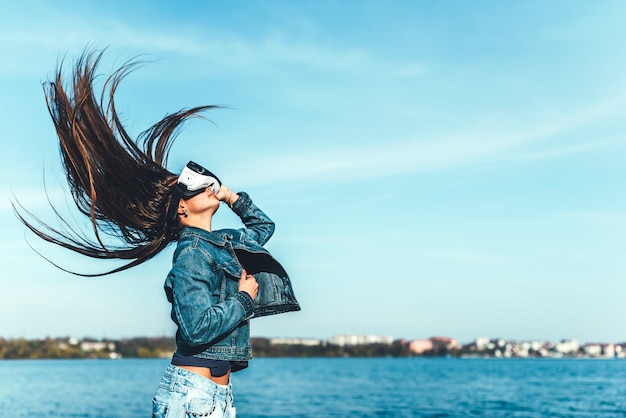 Moça em óculos de realidade virtual no parque