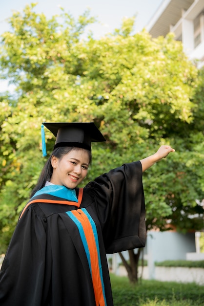 Moça graduada que veste um chapéu preto da borla.