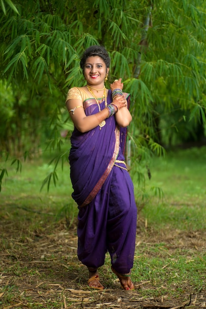 Moça indiana bonita no saree tradicional posando ao ar livre