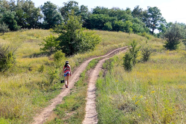 Moça indo embora na estrada rural