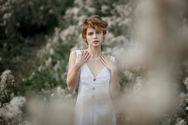 Moça no retrato do campo do vestido branco de uma mulher