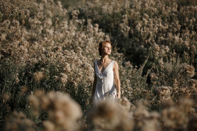 Moça no retrato do campo do vestido branco de uma mulher