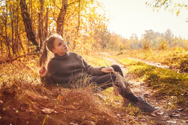 Foto moça que descansa no parque em um dia ensolarado do outono. conceito de estilo de vida adolescente