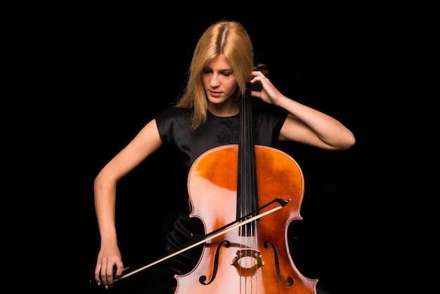 Moça que joga o violoncelo no fundo preto isolado