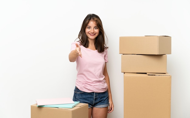Moça que move-se na casa nova entre o aperto de mão das caixas após o bom negócio