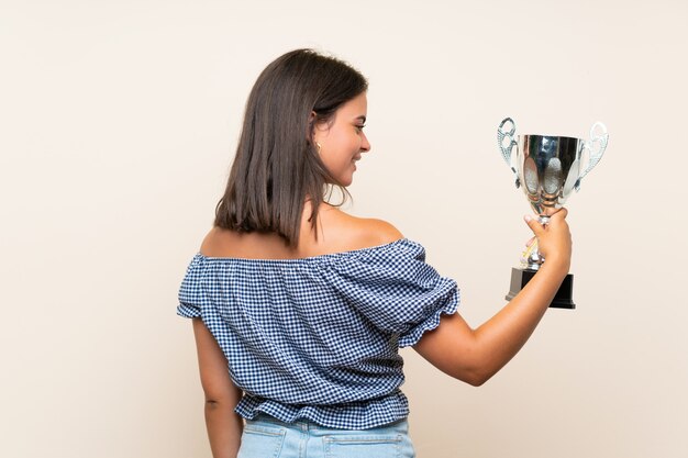 Moça sobre parede isolada, segurando um troféu