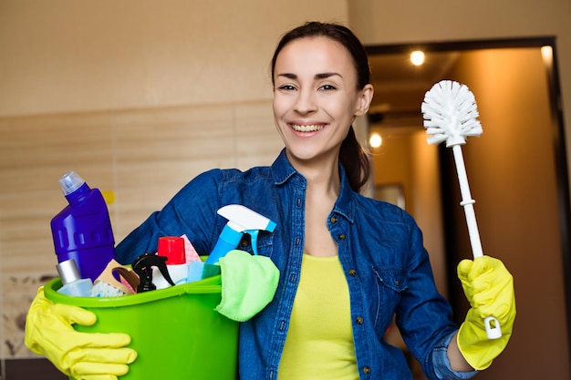 Moça sorridente com o equipamento para limpeza