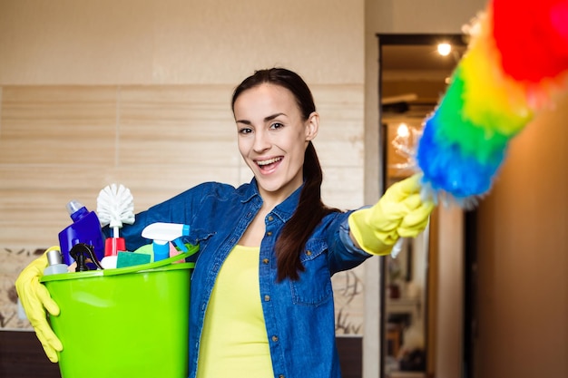 Moça sorridente com o equipamento para limpeza