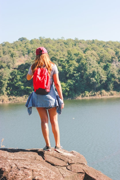 Moças asiáticas com trouxa brilhante que apreciam na natureza durante férias.