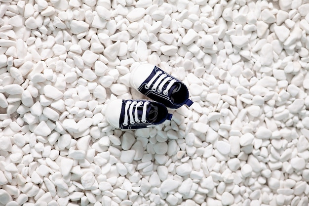 mocasines de niño sobre piedras blancas del mar