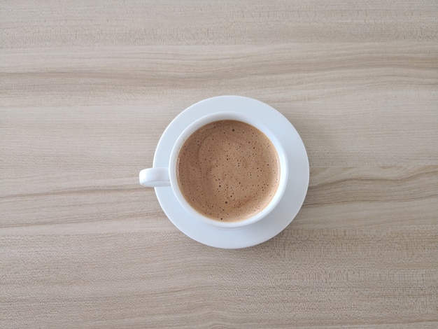 Mocha del café en una taza blanca en una tabla de madera marrón.