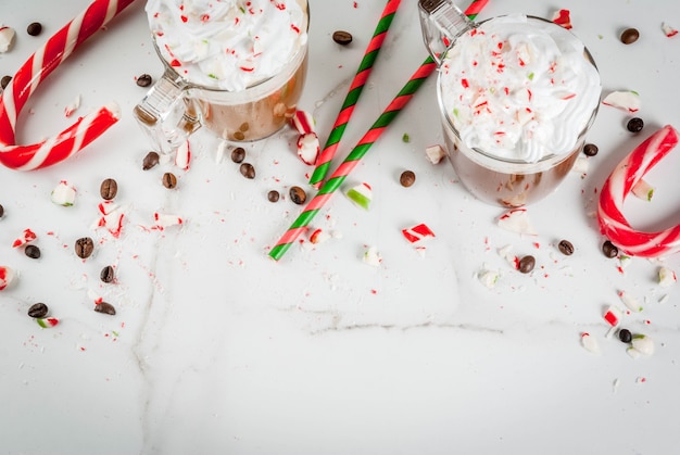 Mocha de hortelã-pimenta caseiro, bebida de café de Natal com bastões de doces, chantilly e calda de hortelã, na mesa de mármore branca, espaço de cópia