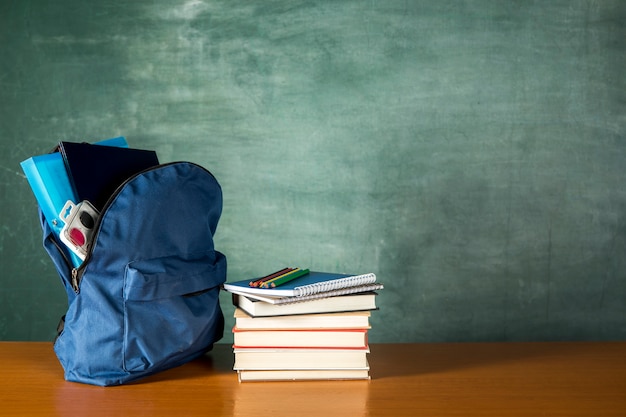 Foto mochila aberta com pilha de livros