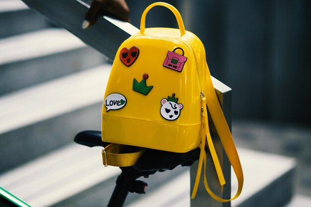 una mochila amarilla con pegatinas que dice "mac".