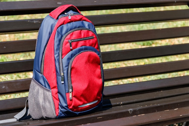 Mochila en banco de madera en el parque de la ciudad