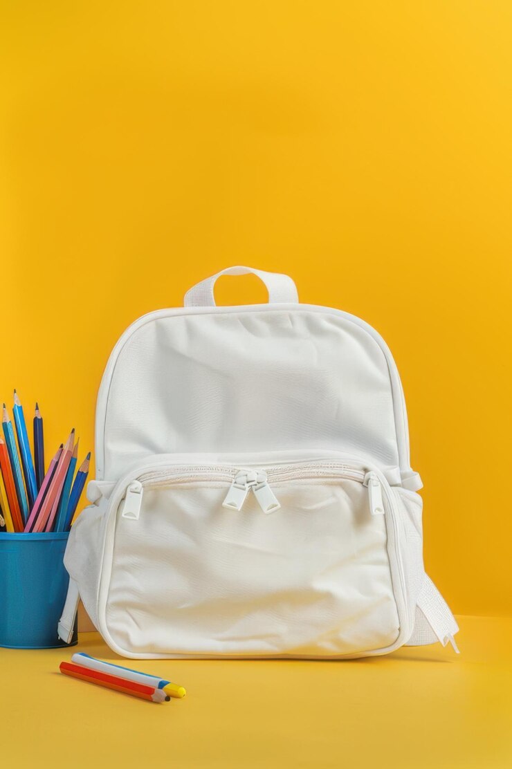 mochila blanca con lápices y libros contra un fondo amarillo brillante perfecto para temas de backtoschool