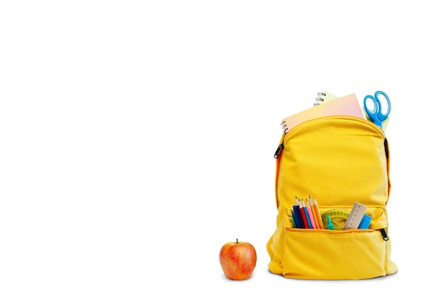 Foto mochila com diferentes artigos de papelaria coloridos e maçã em fundo branco design de banner de volta ao fundo do conceito de escola com o caminho
