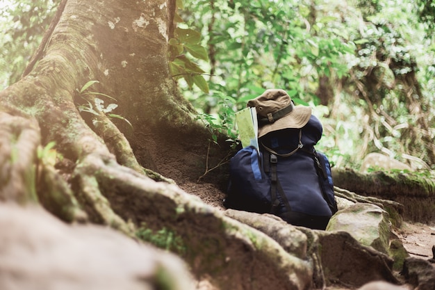 Mochila com mapa e chapéu no chão