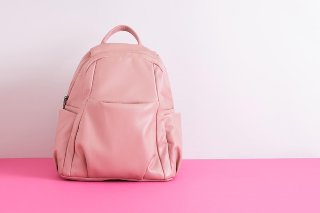 Mochila de cuero rosa en los hombros sobre un espacio de copia de fondo gris maqueta