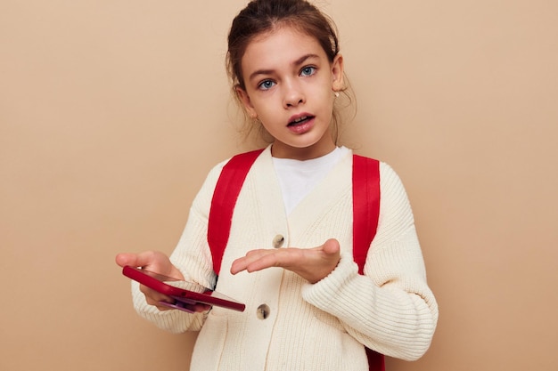 Mochila de colegial muito jovem telefone na mão infância inalterada