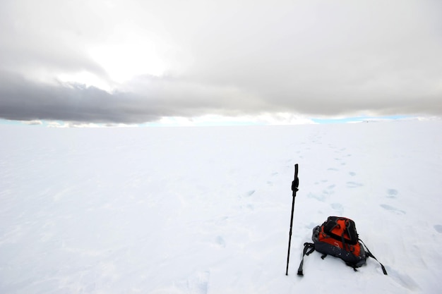 Mochila e bastão na montanha coberta de neve Esportes de inverno Caminhando na neve