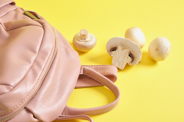 Mochila de ecopiel rosa y champiñones sobre fondo amarillo, piel vegana de micelio