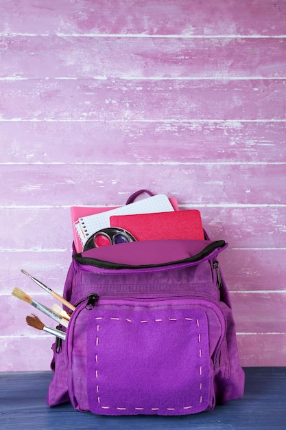 Foto mochila escolar sobre fondo de madera