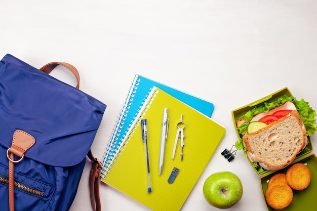 Mochila de estudiante, útiles escolares y bocadillo fresco.