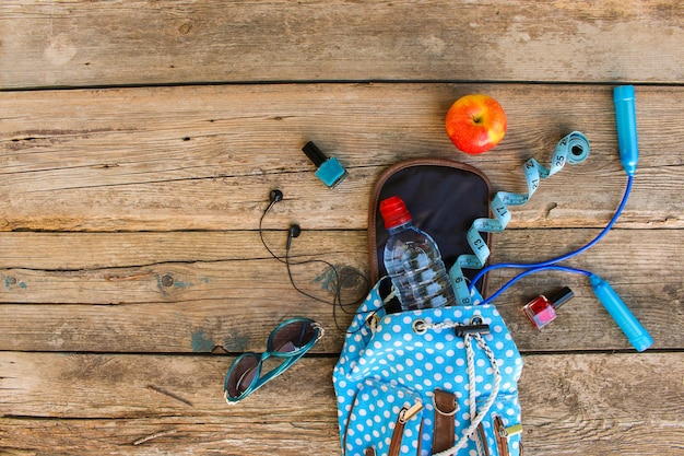 Mochila femenina con equipamiento deportivo, cosmética, cinta métrica y agua.