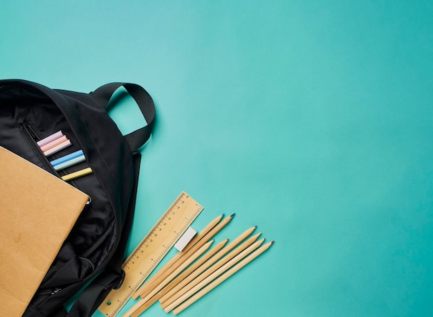 Foto mochila con papelería sobre fondo azul.