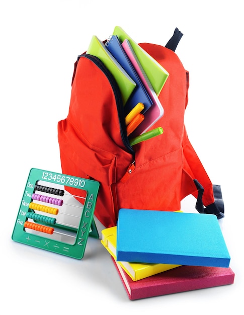 Foto mochila roja con papelería de colores aislado sobre fondo blanco.