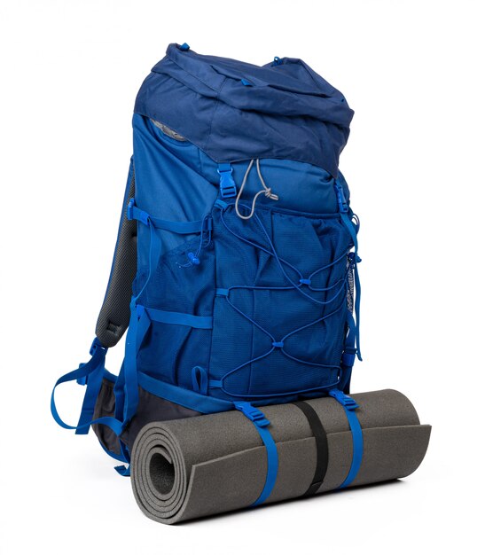 Foto mochila de senderismo azul con colchoneta de fitness aislada en blanco