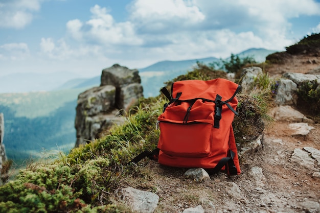 Foto mochila vermelha no topo da montanha