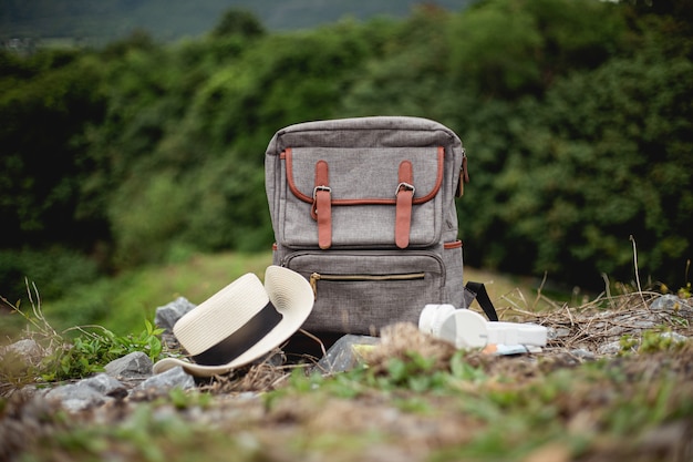 Mochila vintage y teléfono con sombrero de mapa en el día de viaje en vacaciones