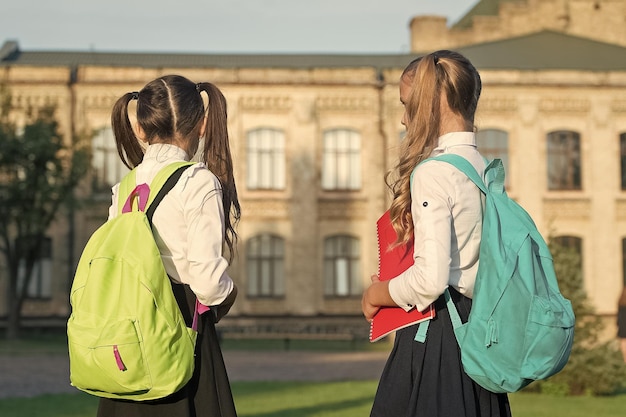 Las mochilas de las niñas estudian juntas en el primer día de la escuela en el concepto de escuela