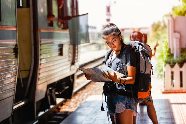 Mochileiro de jovem mulher asiática e viajando olhando o mapa