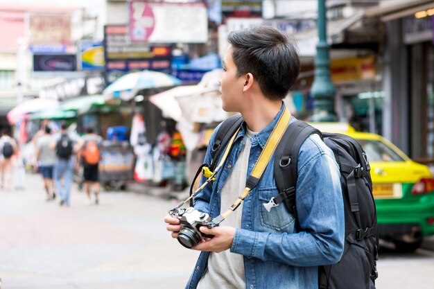 Mochileiro de turista masculino asiático viajando na estrada de khao san, bangkok, tailândia