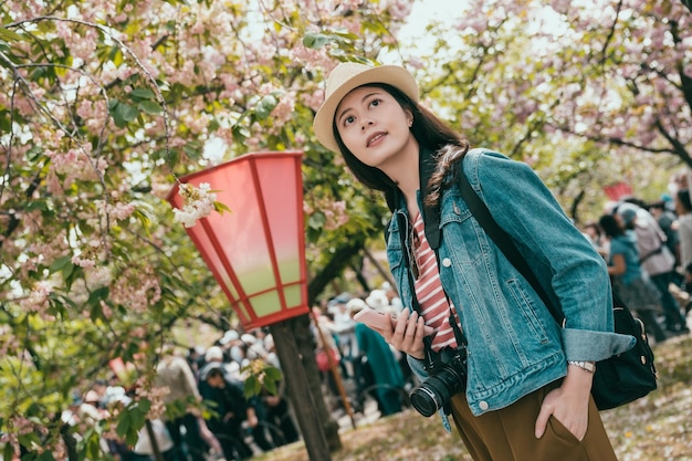 Mochileiro feminino no parque primavera com sakura