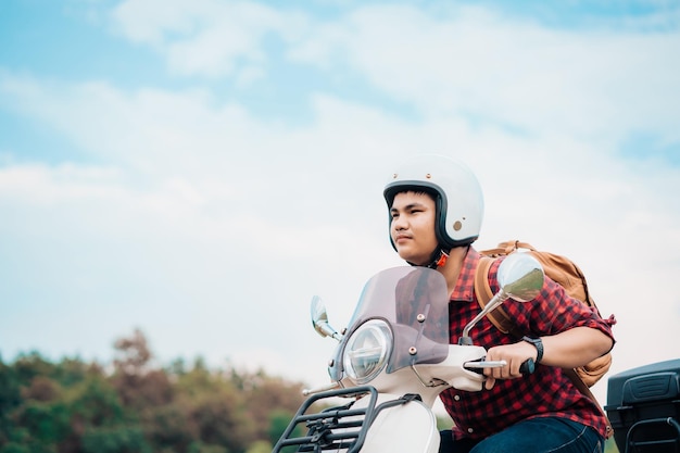 Mochileiro hipster andando de motoneta na estrada Viagens de scooter vida lenta no tempo de descanso de férias