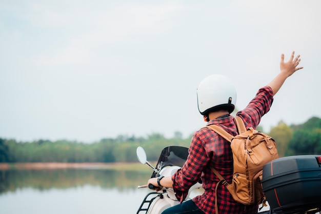 Mochileiro hipster andando de motoneta na estrada Viagens de scooter vida lenta no tempo de descanso de férias