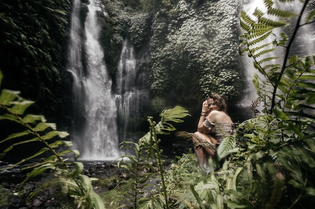 Mochileiro jovem perto de cachoeira nas selvas