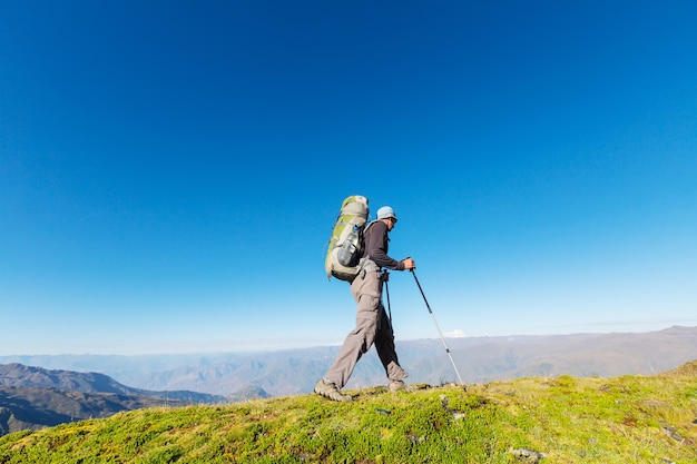 Mochilero en una caminata en las montañas de verano