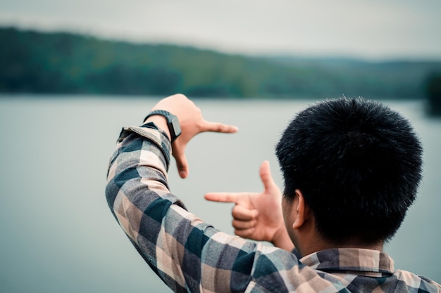 Foto el mochilero captura el momento feliz con la mano en la naturaleza.