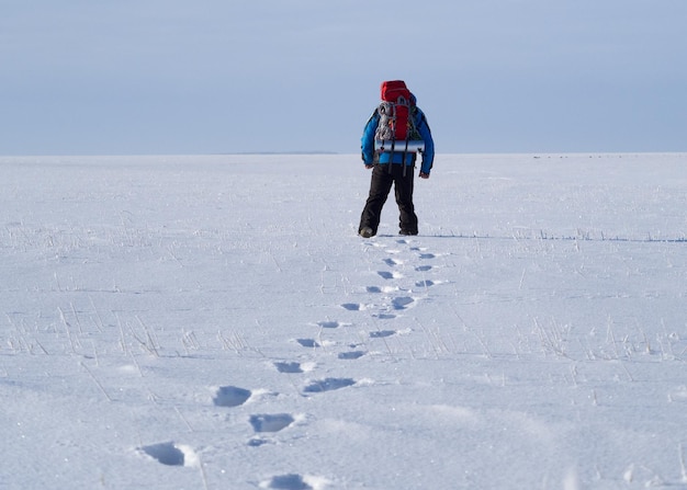 Mochilero solitario caminando tirar nieve desierto vista desde atrás